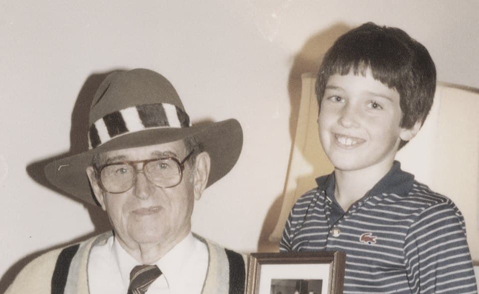 Milton Crow in a fedora, seated beside his young grandson Nick Ostroff